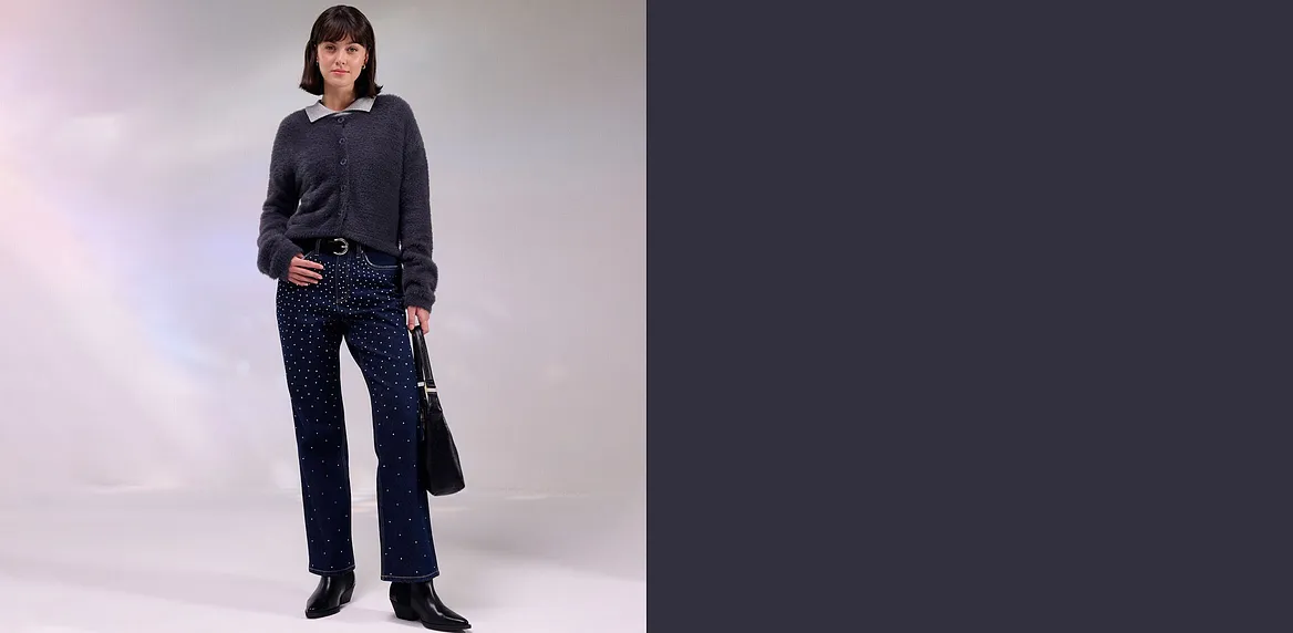 Donkere jas, jeans met stras en bijpassende tas.