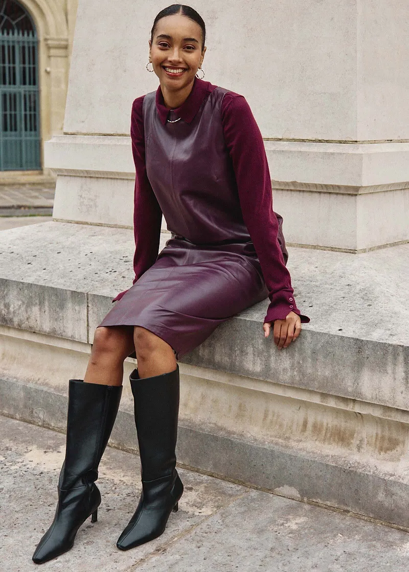 Elegante combinatie van lila trui, grijze spencer en donkerpaarse jurk.