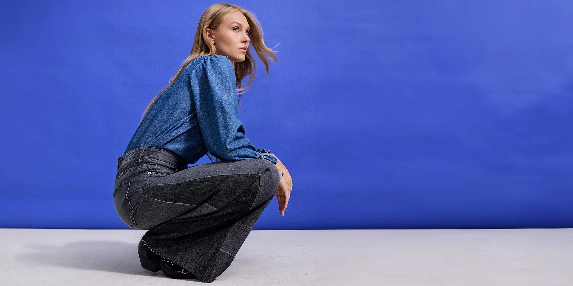 Blauwe blouse met ruches gecombineerd met wijde jeans.