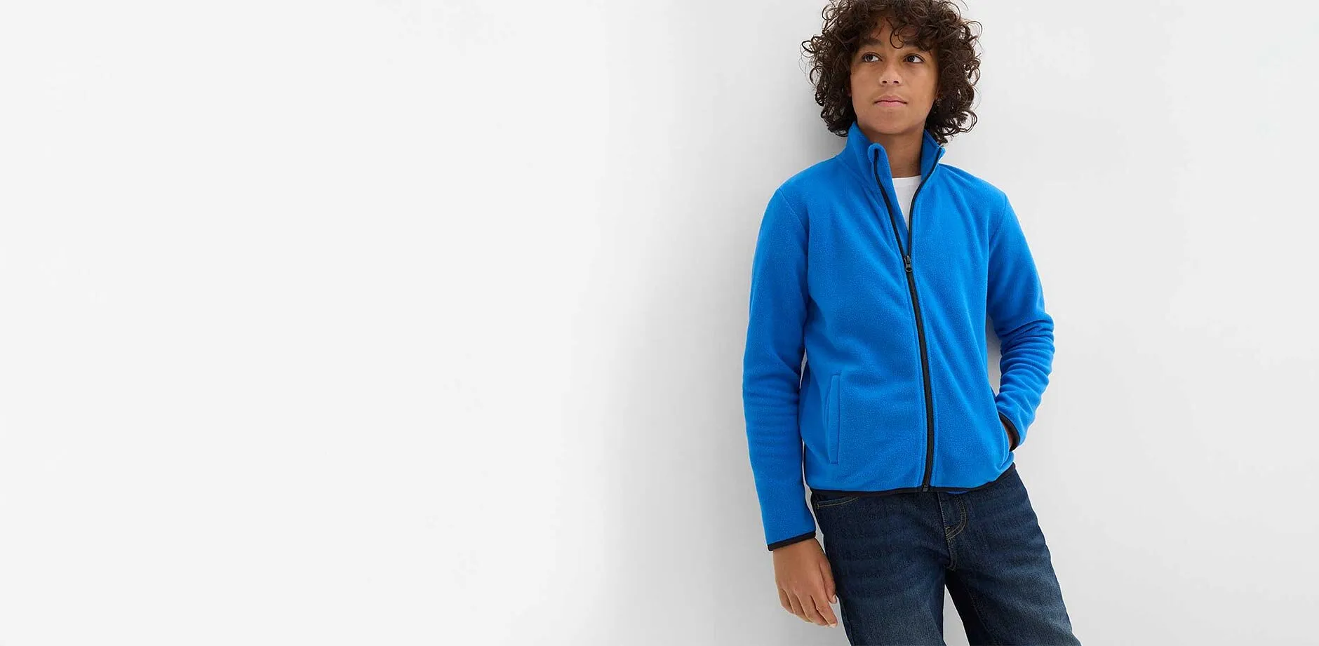 Jongen draagt blauw fleece vest.