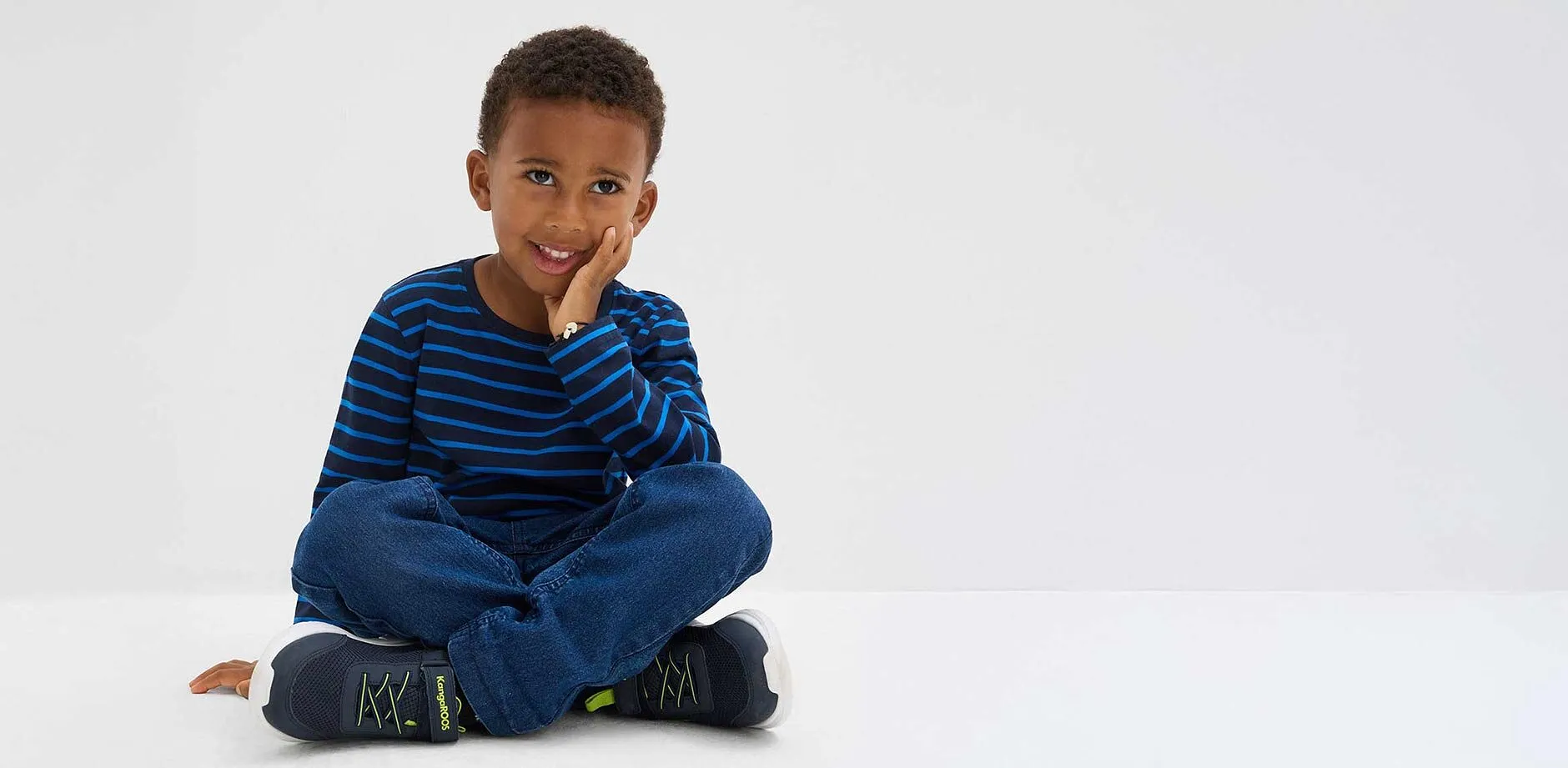 Jongen draagt gestreepte longsleeve.