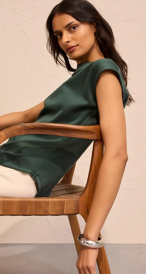Elegante donkergroen shirt op lichte broek