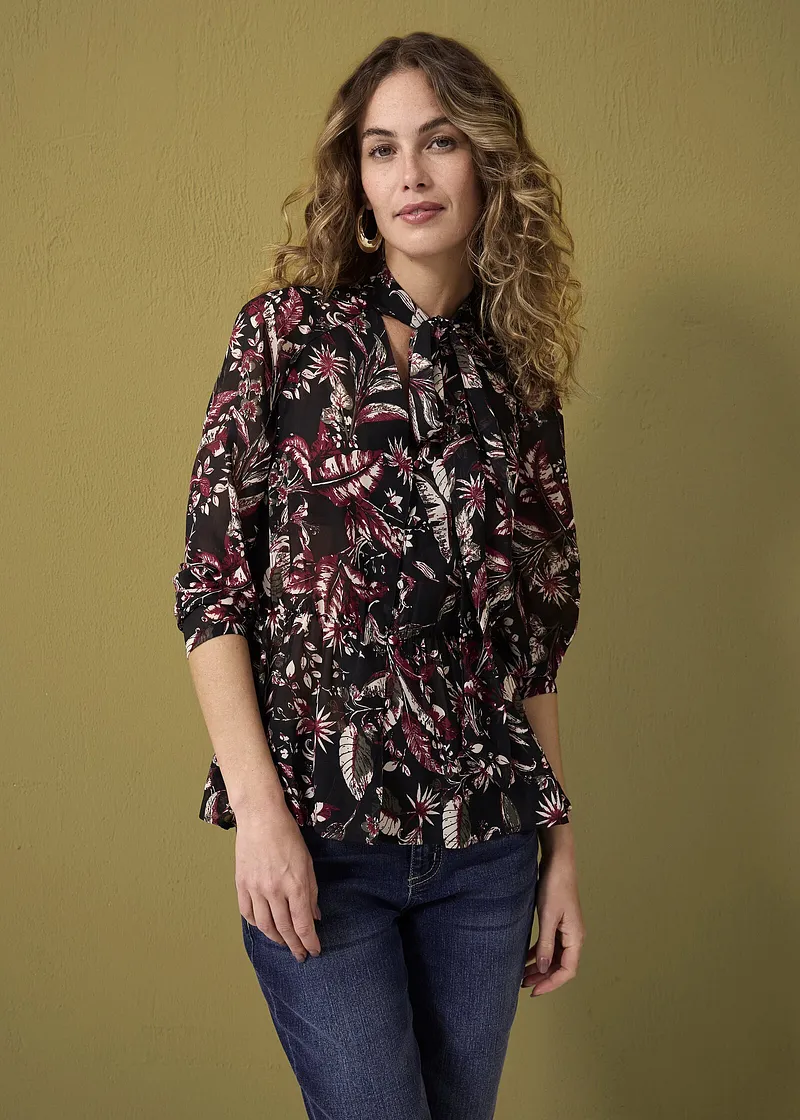 Bloemenblouse met strikkragen, gecombineerd met klassieke jeans. Subtiele boho-chic voor dagelijks gebruik.