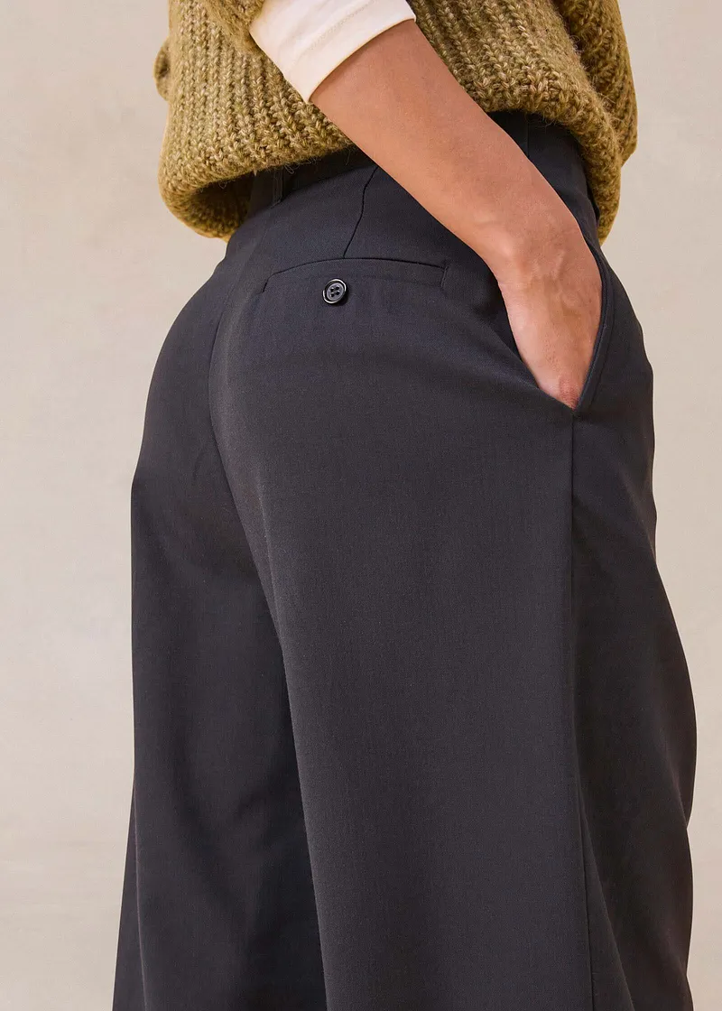 Zwarte broek met zakken gecombineerd met een warme gebreide trui.