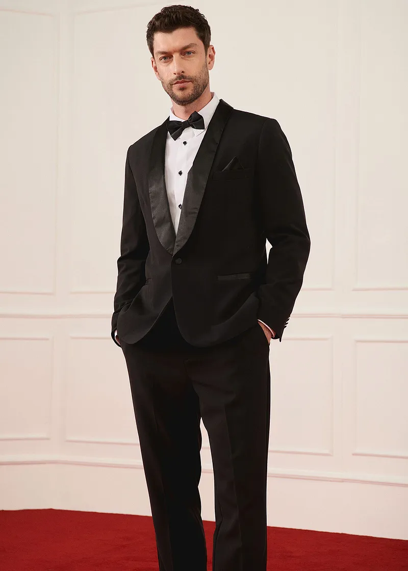 Elegante zwarte smoking met vlinderdas en wit overhemd voor bijzondere gelegenheden.