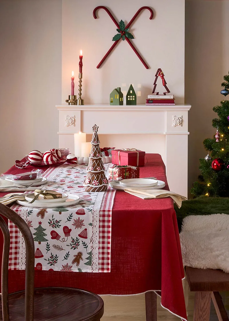 Feestelijk gedekte tafel met tafelkleed met kerstmotief.