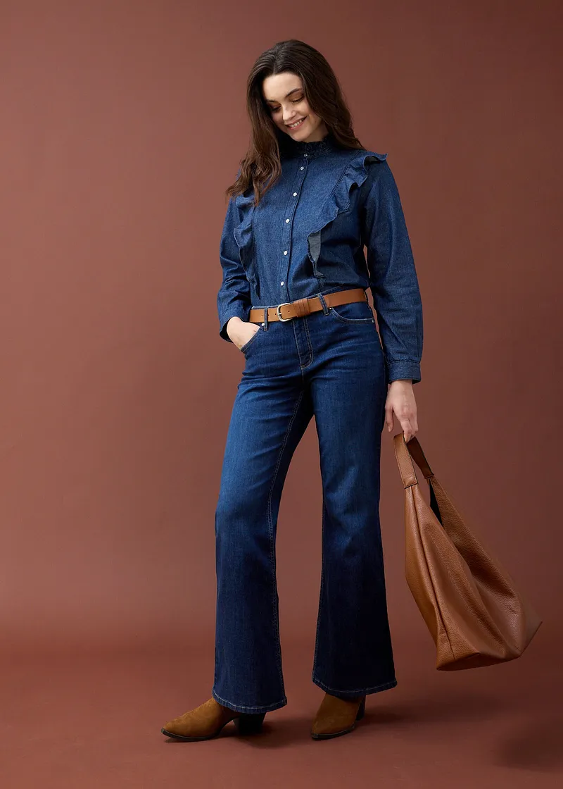 Uitlopende jeans, jeansblouse en bruine riem.