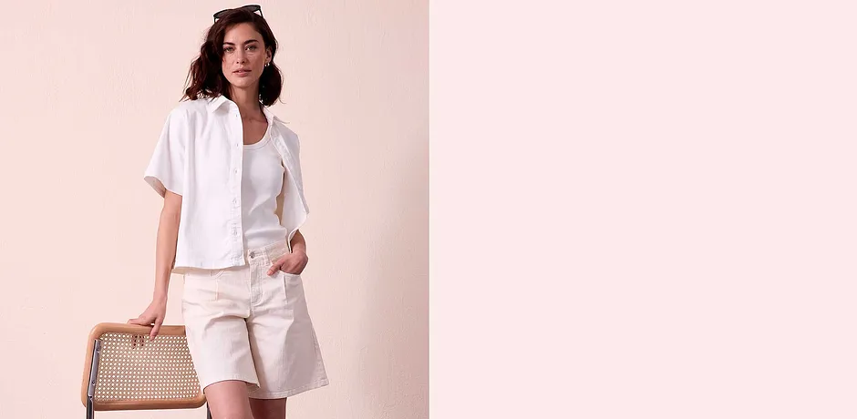Elegante zomerse outfit in wit: blouse met korte mouwen, T-shirt en een broek met zakken.