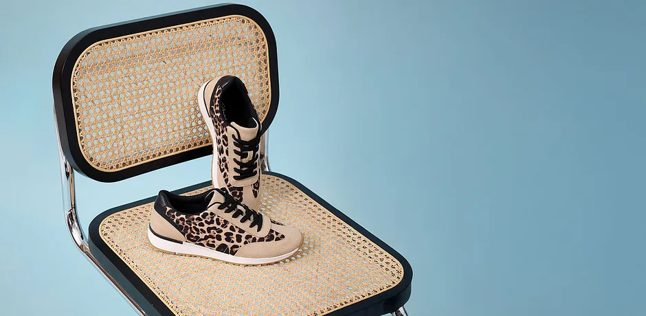 Stylishe panterprint sneakers op een gevlochten ondergrond.