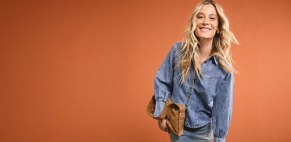 Casual denimlook met een blauw spijkerhemd, bijpassende spijkerbroek en een bruine schoudertas voor een ontspannen dagelijkse stijl.