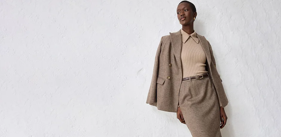 Beigekleurige blazer met een bijpassende trui en rok.
