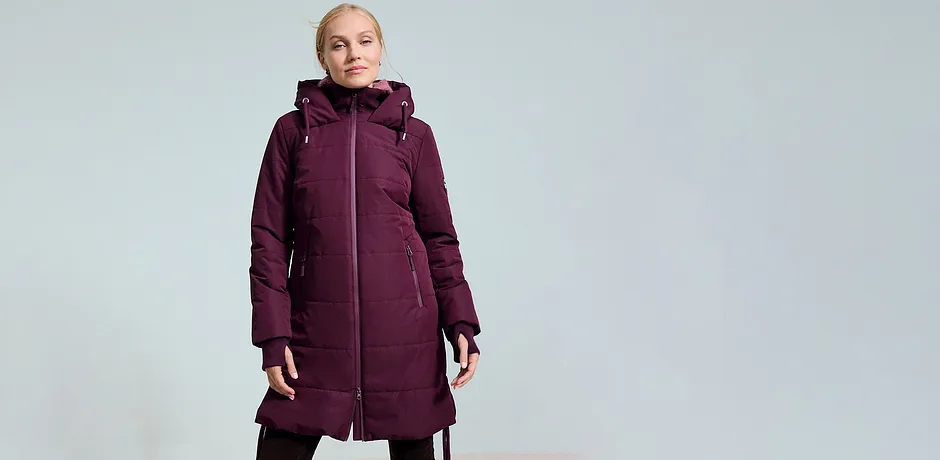 Warme, lange winterjas in donkerrood met capuchon en handige zijzakken voor koude dagen.