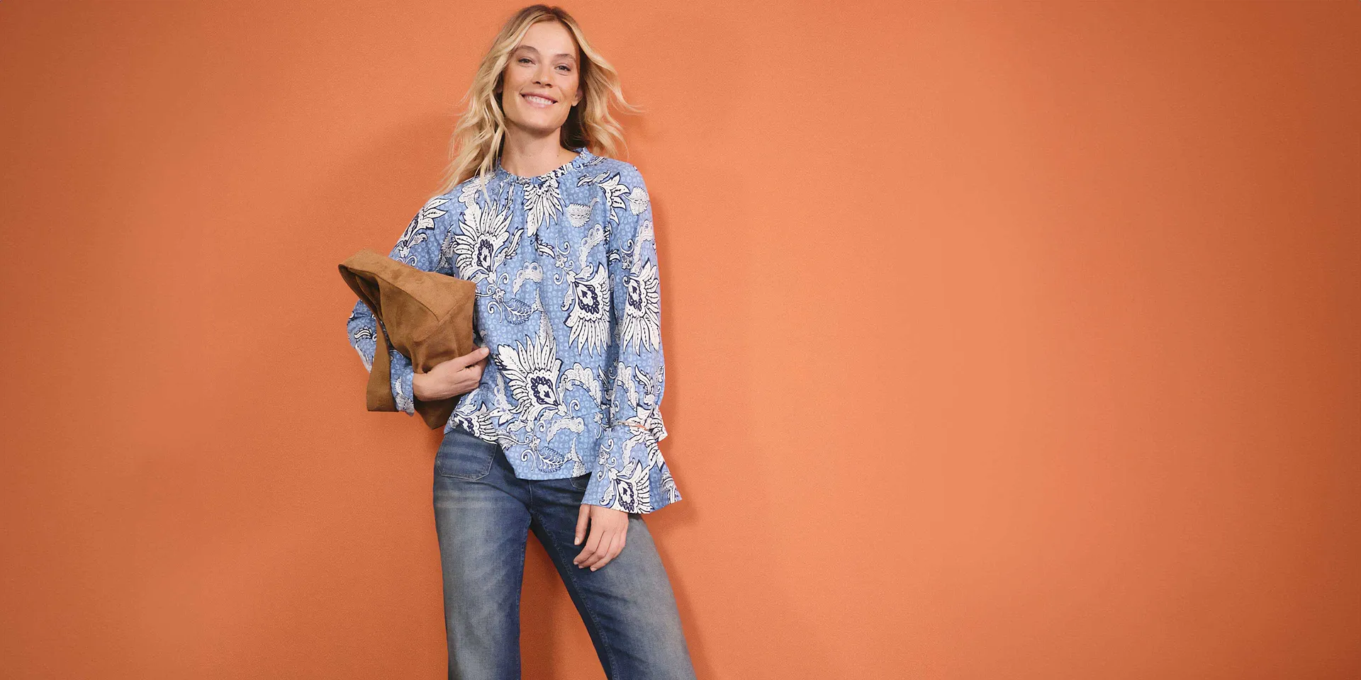 Blauw-witte blouse met een bloemmotief, gecombineerd met jeans. Losse stijl voor een ontspannen look.