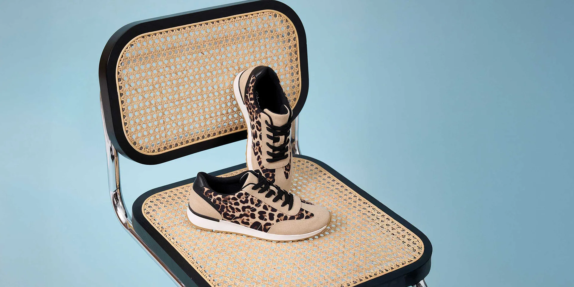 Stylishe panterprint sneakers op een gevlochten ondergrond.