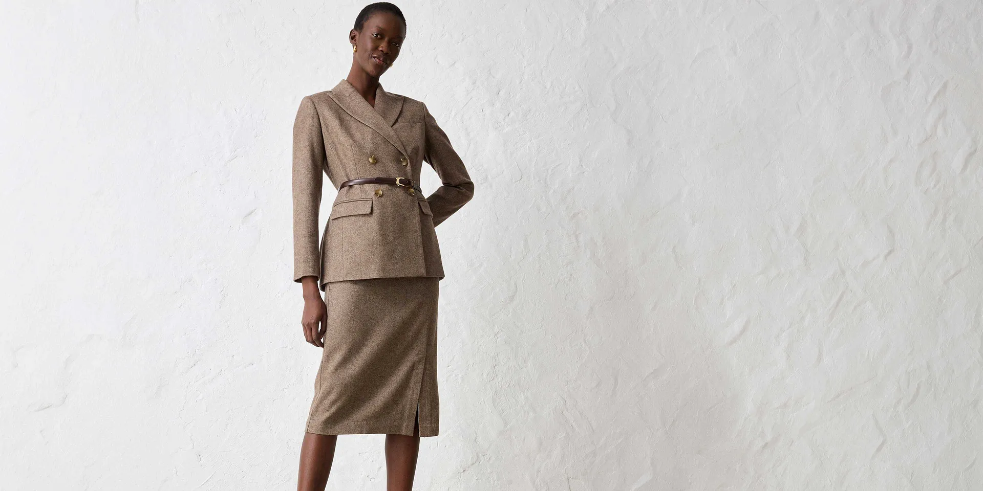 Beige blazer met riem, gecombineerd met een bijpassende rok.