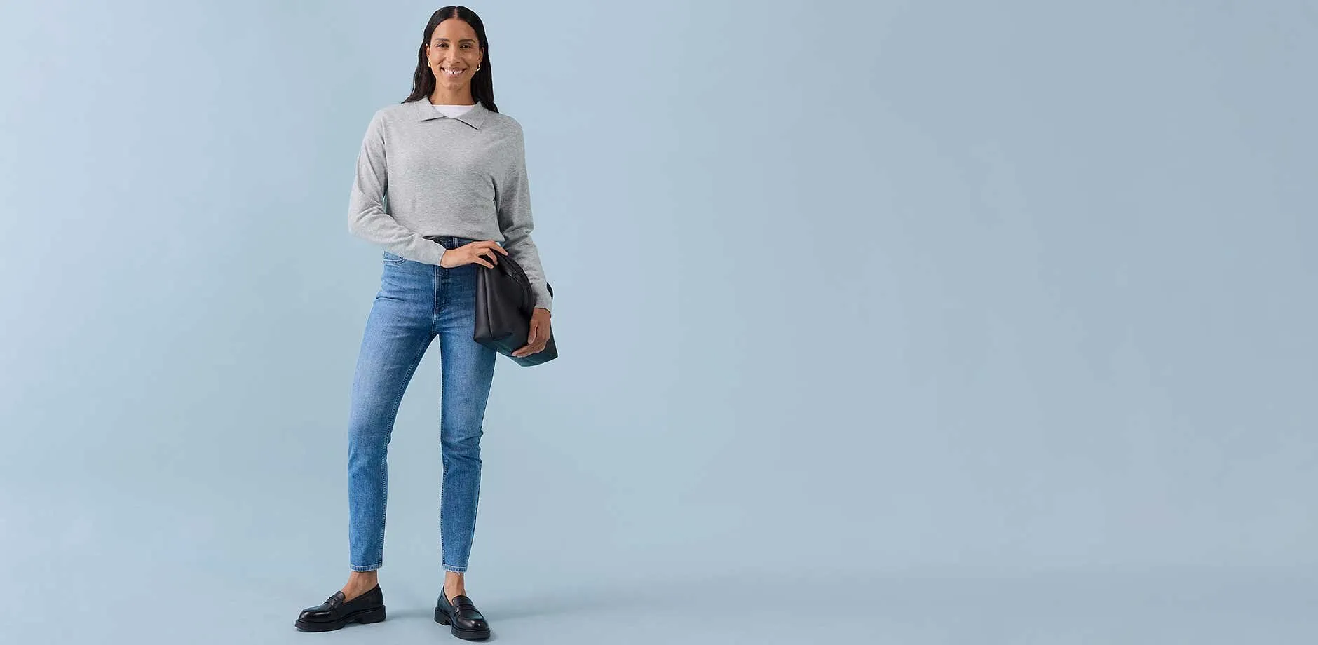Lichtgrijs sweatshirt, blauwe skinny jeans, donkere ballerina’s en een bruine schoudertas.