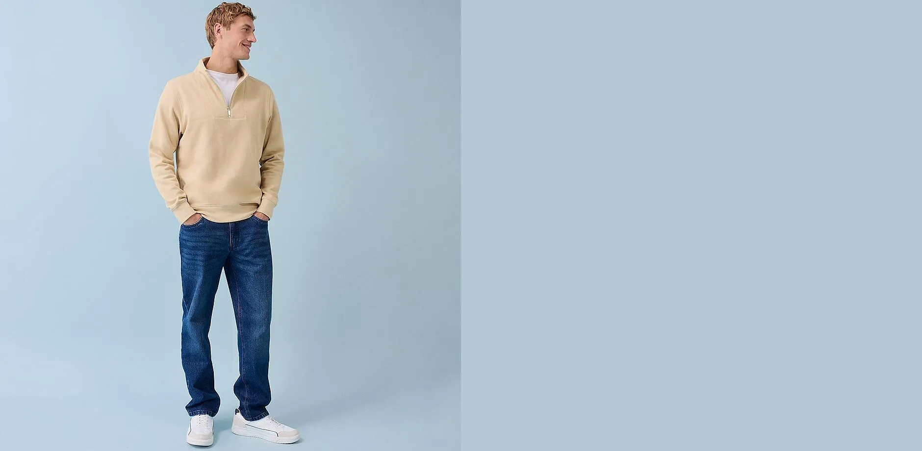 Beige trui met rits, blauwe spijkerbroek en witte sneakers - een casual dagelijkse look voor mannen.