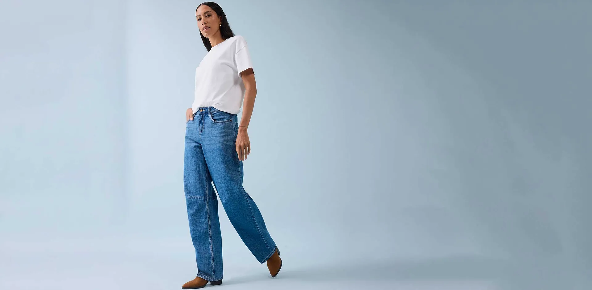 Klassiek wit T-shirt gecombineerd met wijde jeans en bruine schoenen.