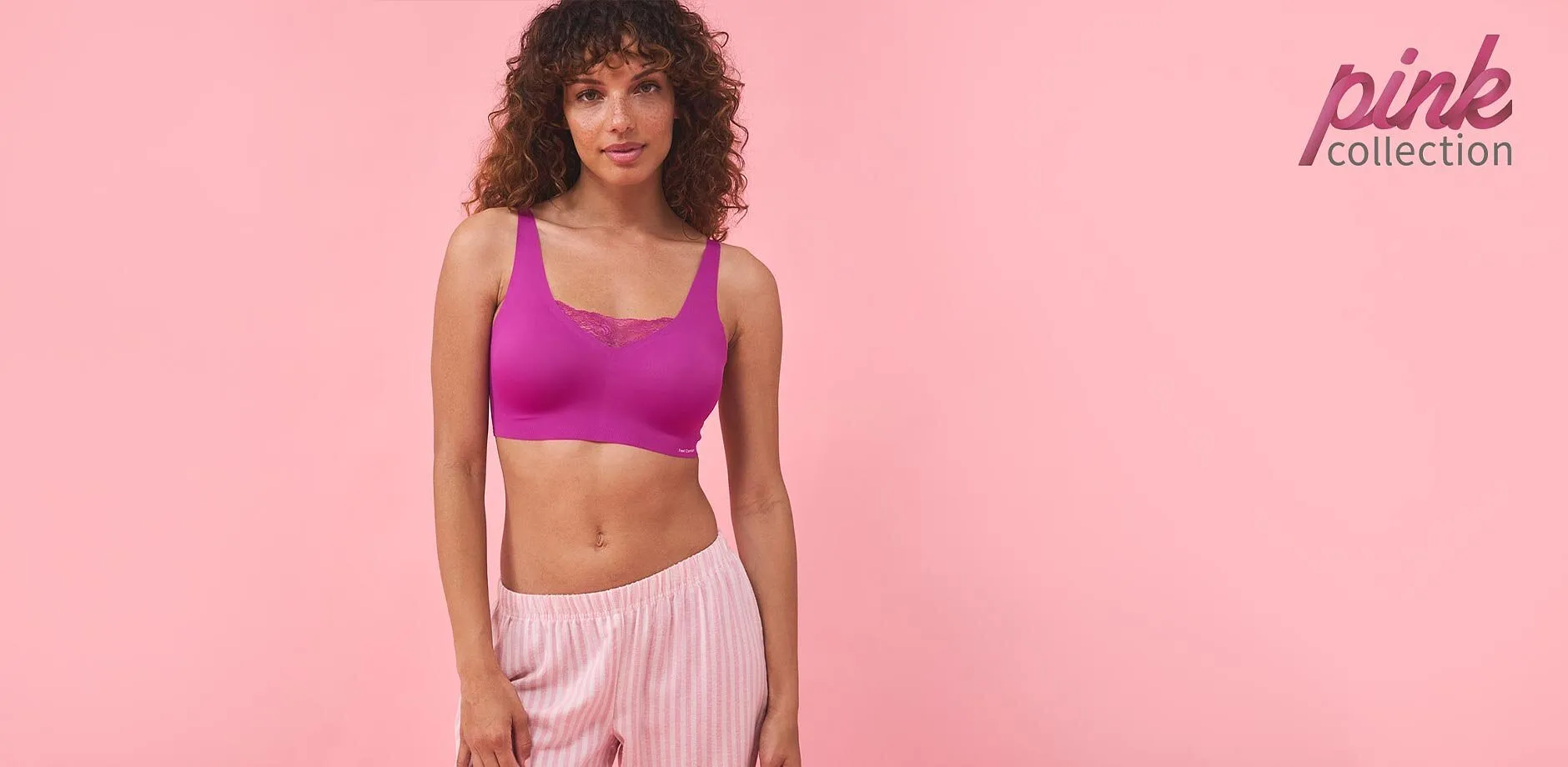 Sportieve outfit: lila croptop en gestreepte roze broek. Perfect voor fitness en vrije tijd.