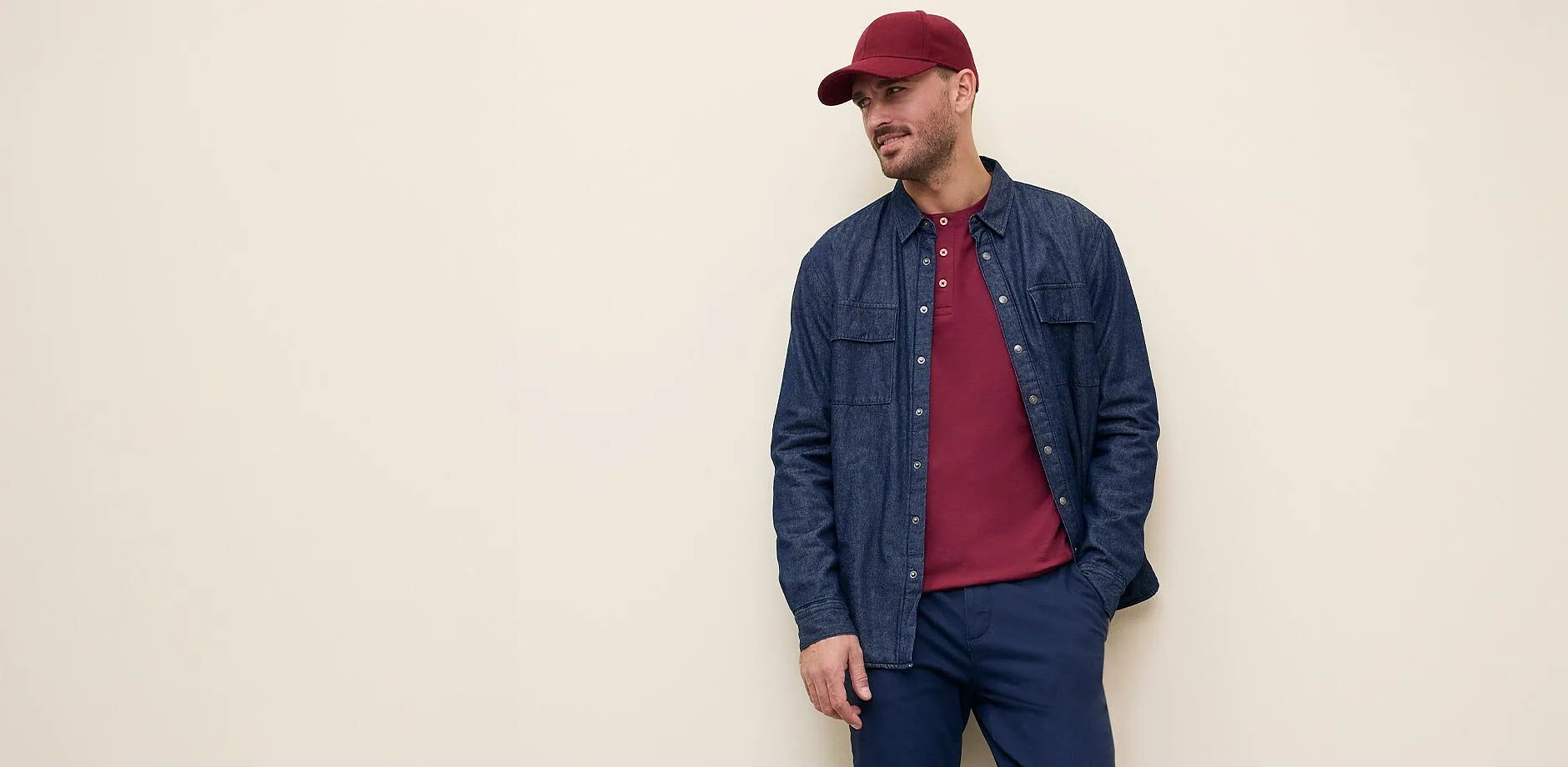 Spijkeroverhemd over shirt, donkere broek.