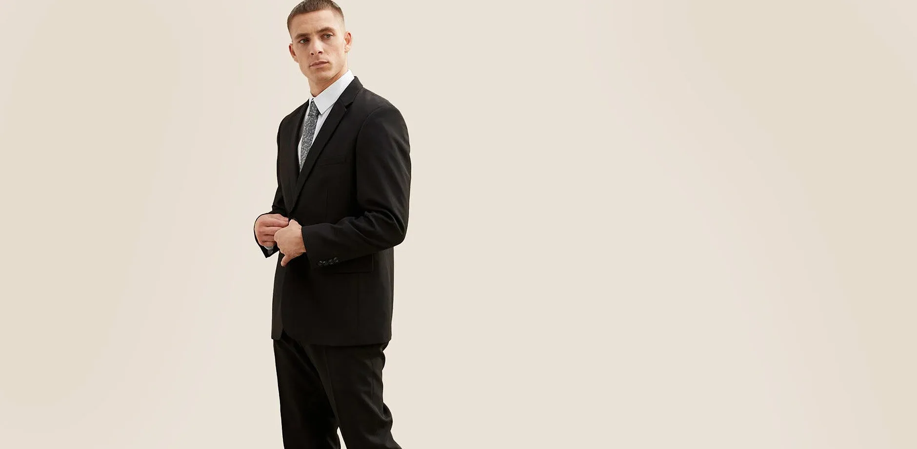 Elegant zwart pak met wit overhemd en stropdas.