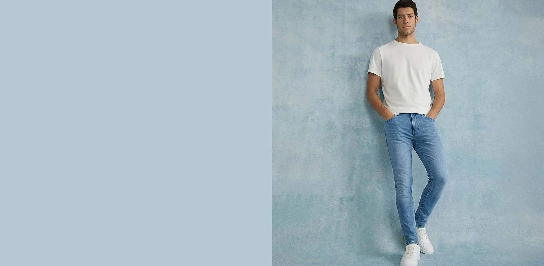 Wit T-shirt, blauwe slim fit jeans en witte sneakers.