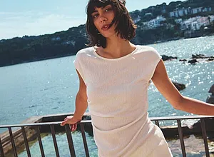 Leichtes, weißes Sommeroutfit: Luftiges T-Shirt und bequeme Hose für einen entspannten Tag am Meer.