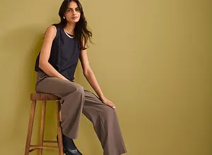 Donkerblauwe top, wijde bruine broek en zwarte laarzen. Elegante, casual look.