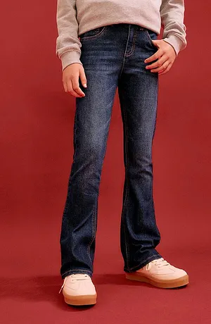 Comfortabele jeans en een grijze trui, gecombineerd met pastelkleurige sneakers - een casual dagelijkse look.