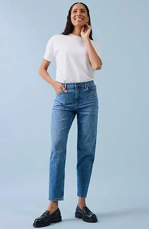 Casual look met wit T-shirt, blauwe spijkerbroek en zwarte schoenen.