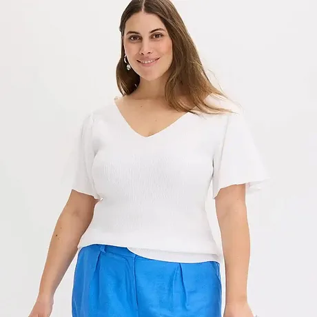 Eenvoudig wit T-shirt met V-hals, gecombineerd met felblauwe broeken voor een frisse zomerlook.