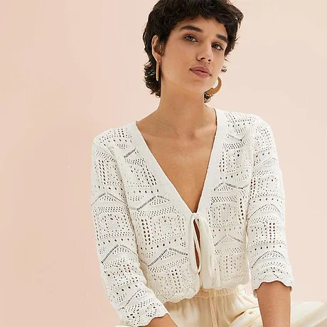 Luchtige witte cardigan met een opengewerkt patroon, perfect voor zomerse dagen.