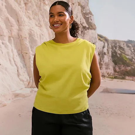 Sommerliche Mode: Ärmellose gelbes Shirt strahlt Leichtigkeit aus.