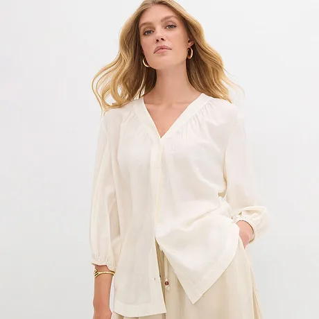 Elegante cremefarbene Bluse mit V-Ausschnitt und weiten Ärmeln.
