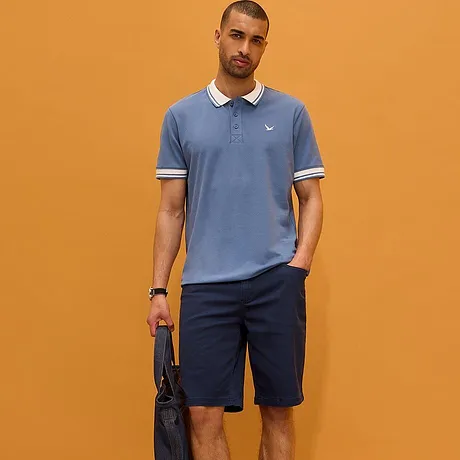 Lichtblauw poloshirt met witte kraag en donkere broek. Sportief-elegante look voor elke dag.