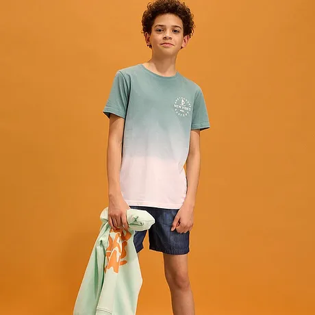 T-shirt met kleurverloop, donkere shorts en een licht sweatshirt om overheen te dragen.