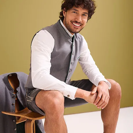 Elegant contrast: Wit overhemd, grijs gilet en korte broek.