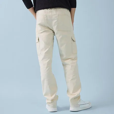 Casual combinatie van een zwarte trui en een lichte cargobroek.
