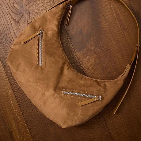 Elegante bruine leren tas met meerdere ritssluitingen.