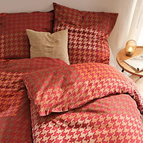 Een dekbedovertrek in warme herfstkleuren en een elegant hanenpootmotief brengt gezelligheid in je slaapkamer.