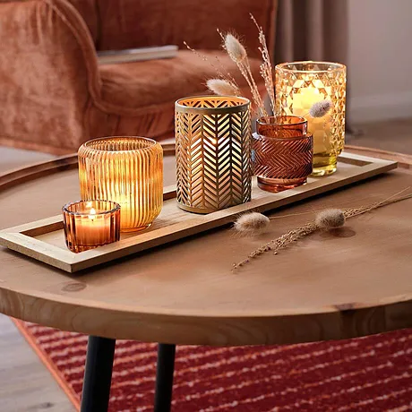 Een gezellige herfstsfeer met warme lichtjes. De fluwelen bekleding van de fauteuil nodigt uit tot vele ontspannen uurtjes.