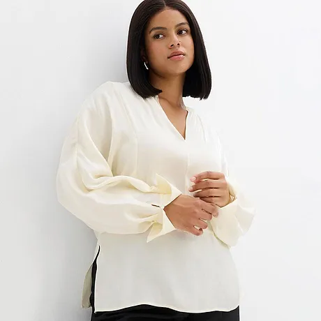 Elegante witte blouse met een V-hals en wijde mouwen.