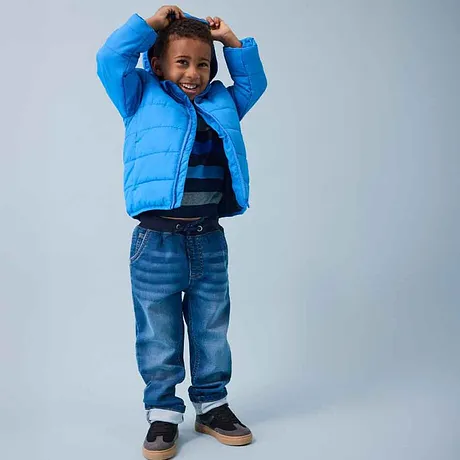 Blauwe donzen jas, gestreept shirt en jeans - vrolijke kindermode voor het koude seizoen.