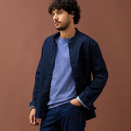 Donkerblauw spijkeroverhemd en lichtblauw shirt gecombineerd met een donkerblauwe broek.