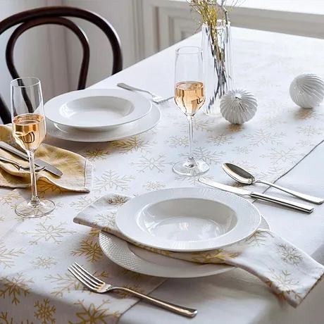 Wit tafelkleed met goudkleurig motief om de feestelijk gedekte tafel mee aan te kleden.