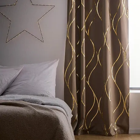 Elegant overgordijn met goudkleurig motief als pronkstuk in de slaapkamer.