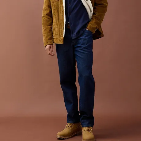 Blauwe jeans, mosterdgele corduroy jas en robuuste beige boots.