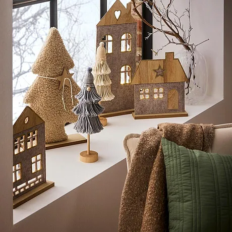 Winterdecoratie in warme bruintinten zorgt voor een gezellige sfeer bij het raam.