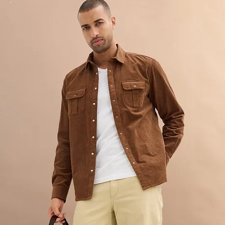 Bruin overhemd over wit T-shirt, gecombineerd met lichte broek.