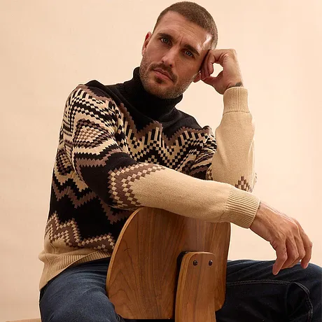 Warme trui met geometrisch motief en blauwe jeans.